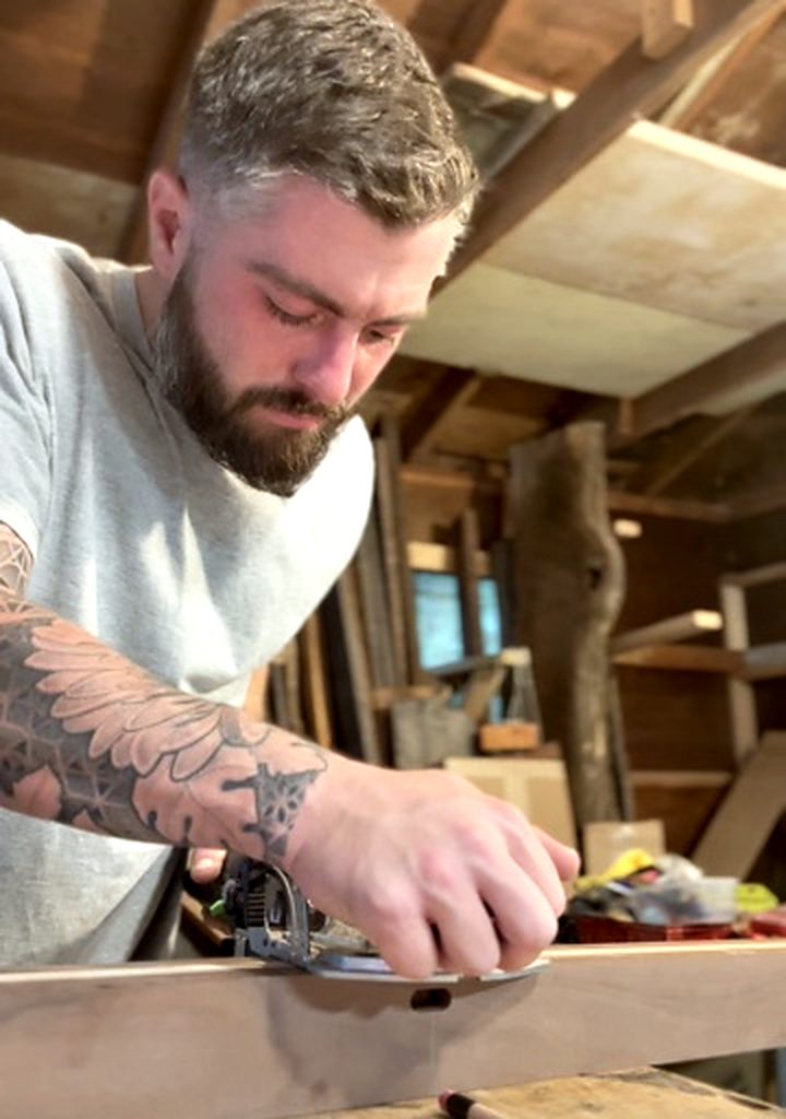 Austin Self working a board at the bench in the shop