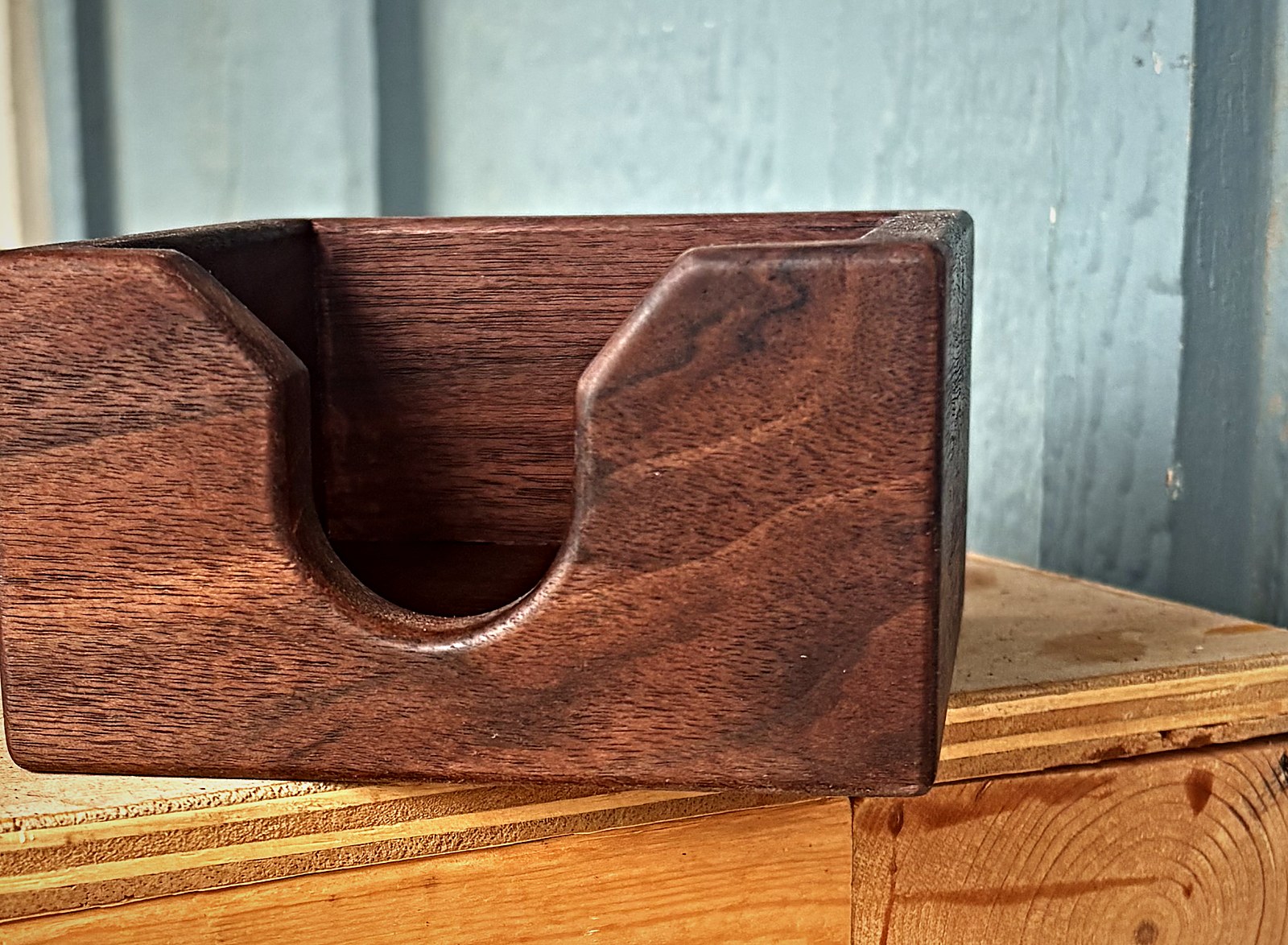 A finished walnut piece resting on the shop bench