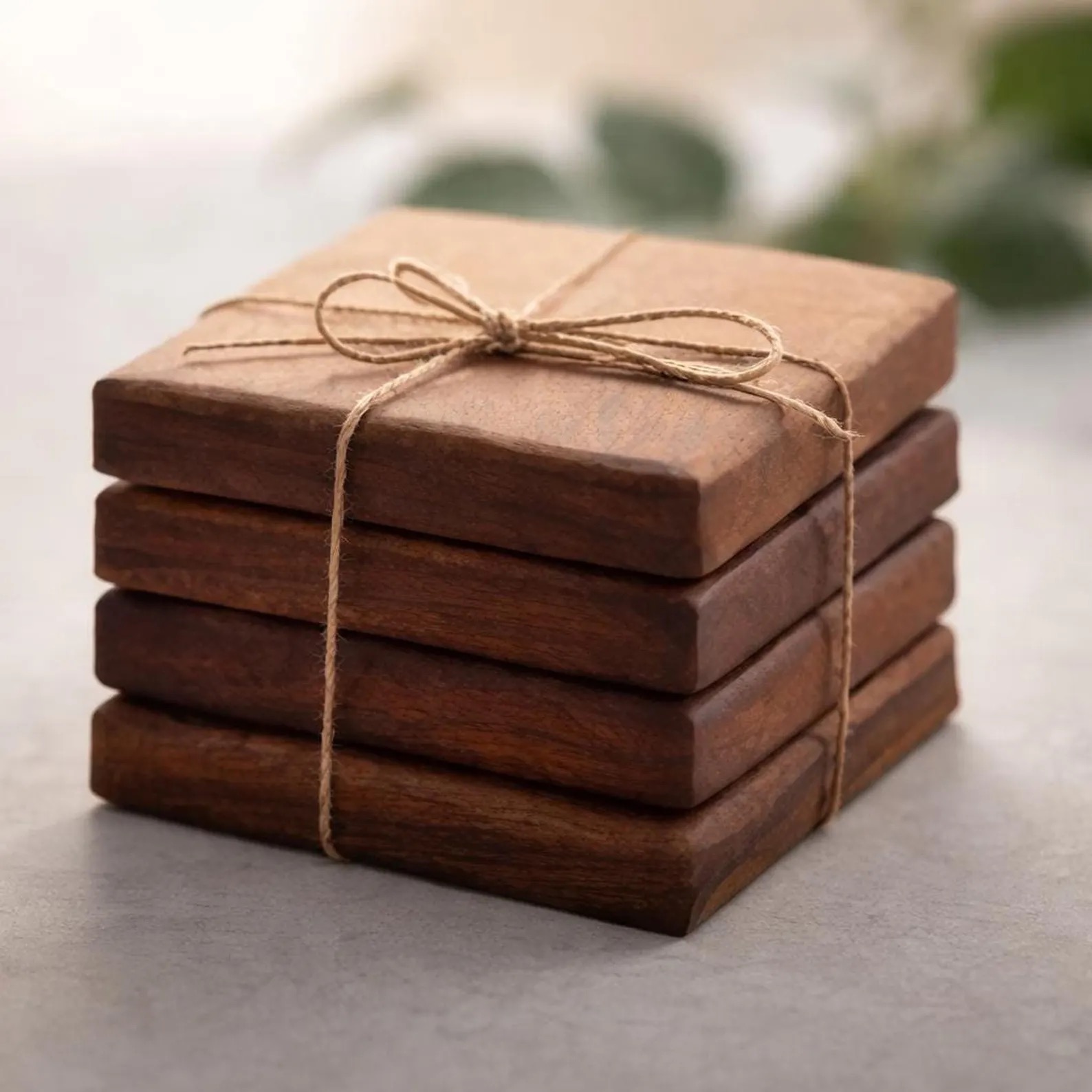 A set of walnut coasters stacked and tied with jute